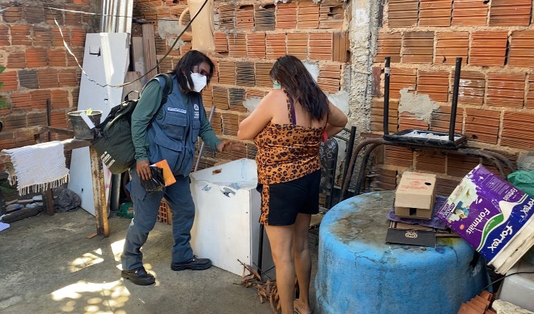 agente de saúde conversa com uma mulher em um quintaç